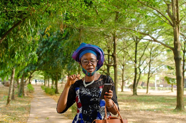 Belle femme africaine dans le sentiment excité de ce qu'elle a vu sur son téléphone portable