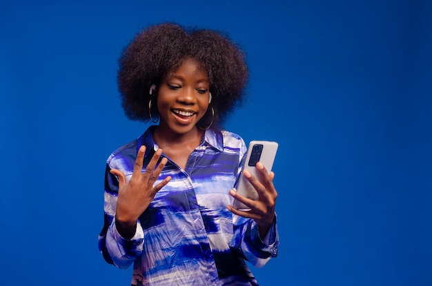 Belle femme africaine se sentant excitée par ce qu'elle a vu sur son téléphone