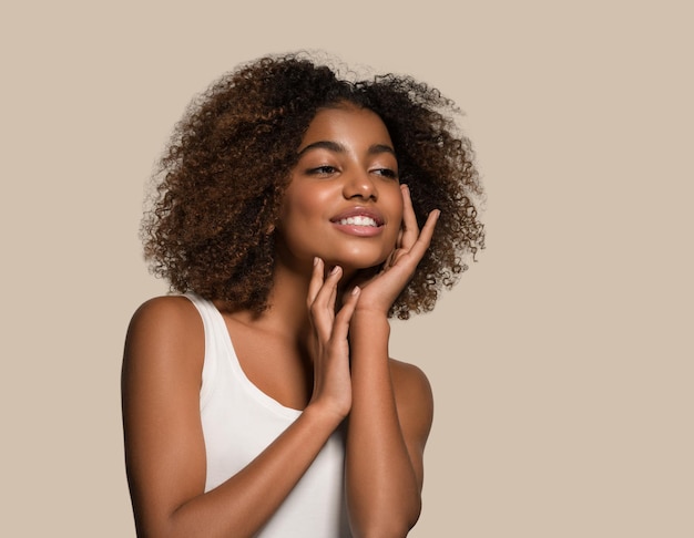 Belle femme africaine t-shirt blanc portrait coupe de cheveux afro touchant son visage Fond de couleur marron