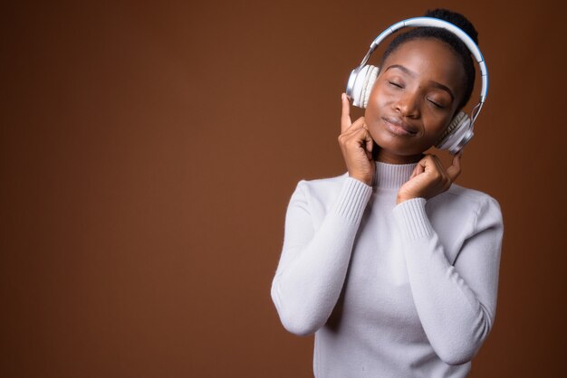 Belle femme africaine zoulou écoutant de la musique avec les yeux fermés