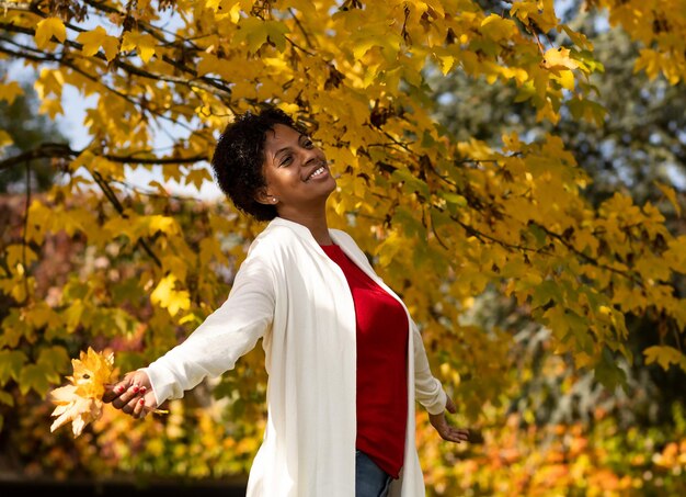 Belle femme afro-américaine marchant dans un jardin d'automne