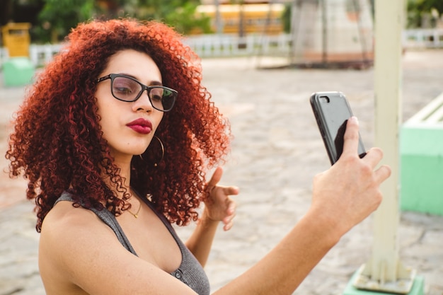 Belle femme afro-américaine prenant un selfie avec son téléphone