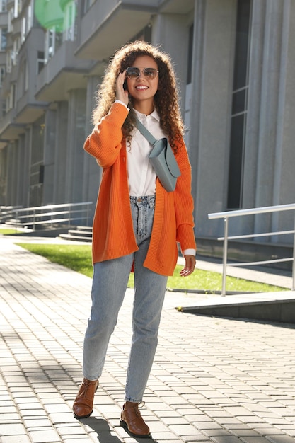 Belle femme afro-américaine avec sac de taille élégant sur la rue de la ville