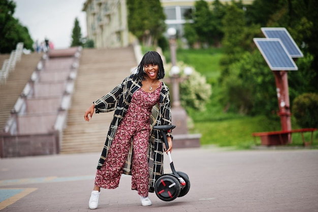 Belle femme afro-américaine tenir sur les mains segway ou hoverboard Fille noire avec scooter électrique auto-équilibré à deux roues
