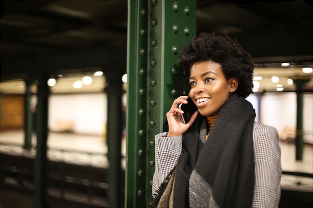 Belle femme afro dans une station de métro