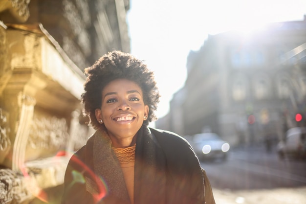 Belle femme afro heureuse qui marche dans la ville