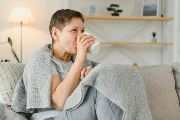 Belle femme d'âge moyen ayant une matinée calme et appréciant son café