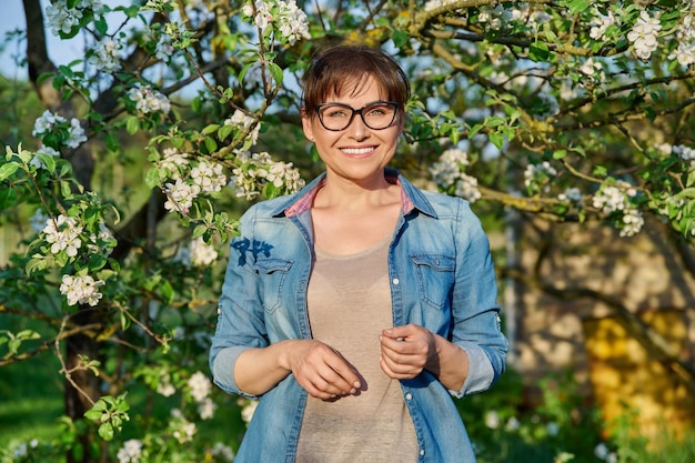 Belle femme d'âge moyen dans un jardin fleuri