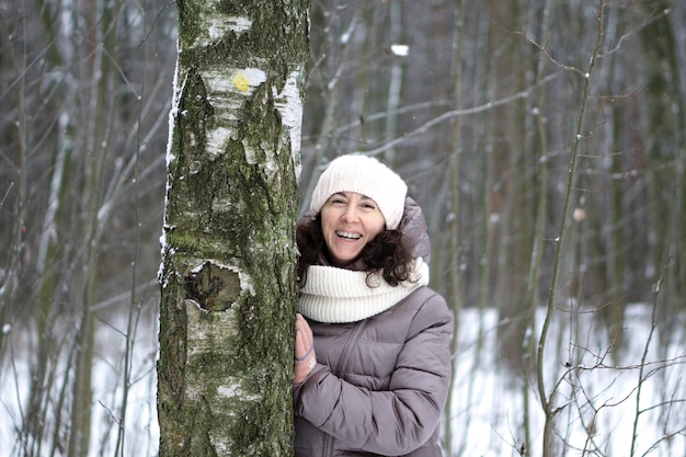 Belle femme d'âge moyen souriante en hiver à l'extérieur. Concept d'hiver