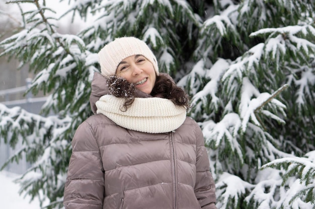 Belle femme d'âge moyen souriante en hiver à l'extérieur. Concept d'hiver