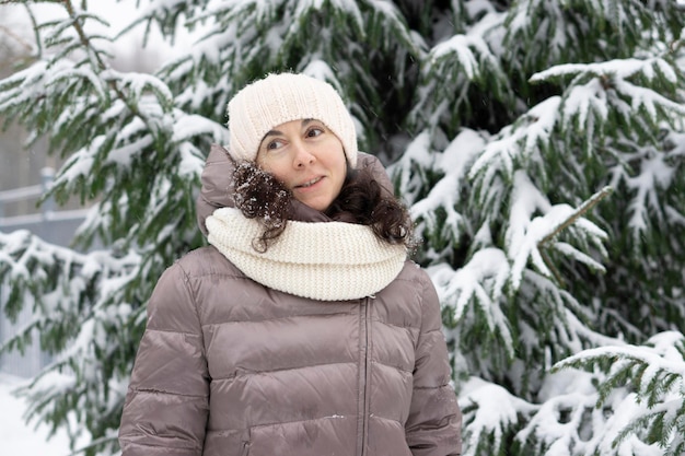 Belle femme d'âge moyen souriante en hiver à l'extérieur. Concept d'hiver