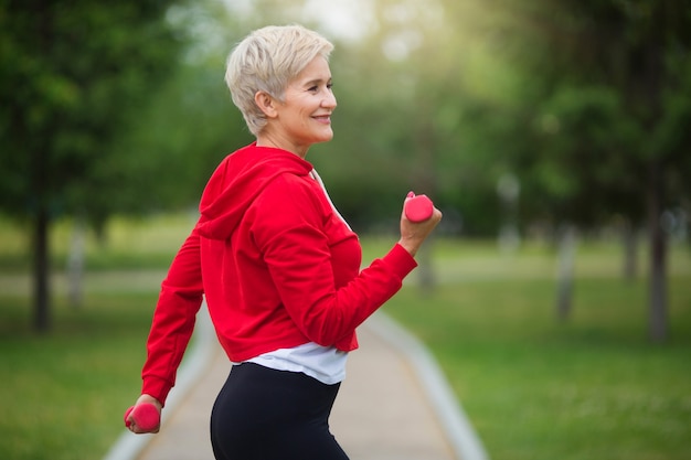 belle femme âgée avec une coupe courte va faire du sport dans le parc