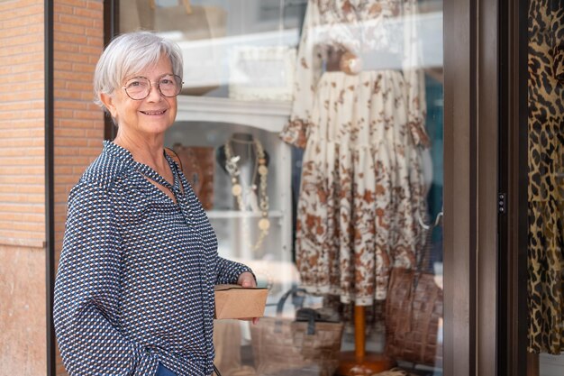 Belle femme âgée devant une vitrine