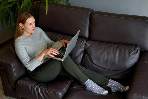 Belle femme à l'aide d'un ordinateur portable à la maison