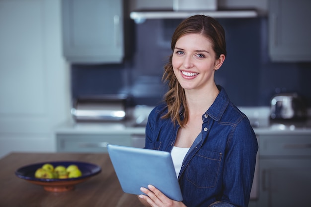 Belle femme à l'aide de tablette numérique dans la cuisine