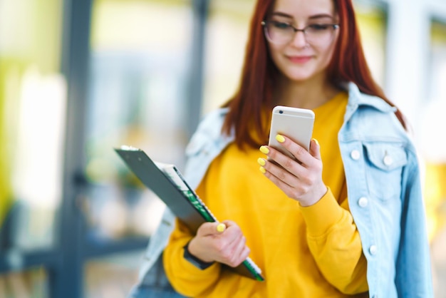 Belle femme à l'aide de téléphone dans un immeuble de bureaux