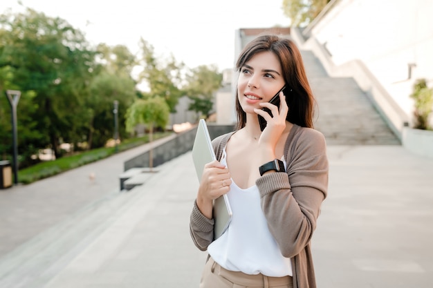 Belle femme à l'aide de téléphone à l'extérieur dans le parc de la ville