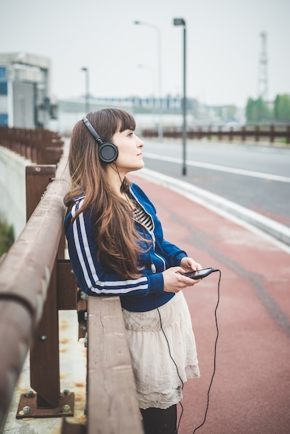 belle femme à l&#39;aide de téléphone intelligent et de la musique à l&#39;écoute