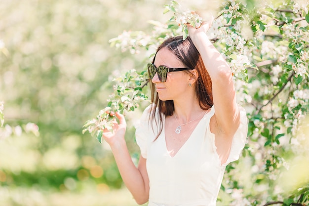 Belle femme appréciant l'odeur au printemps jardin de cerises