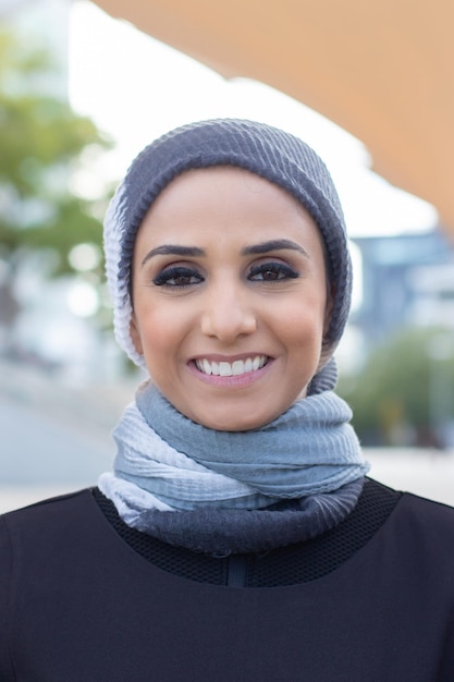 Belle femme arabe souriante. Portrait de femme avec tête couverte et maquillage regardant la caméra avec un sourire éclatant. International, beau concept