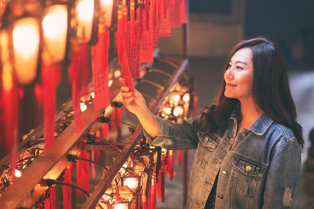 Une belle femme asiatique aimait regarder des lampes rouges et des vœux dans un temple chinoisUne belle femme asiatique aimait regarder des lampes rouges et des vœux dans un temple chinois