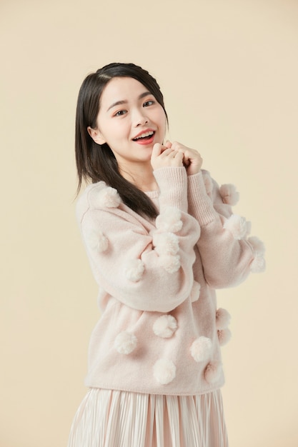 Belle femme asiatique dans un pull beige