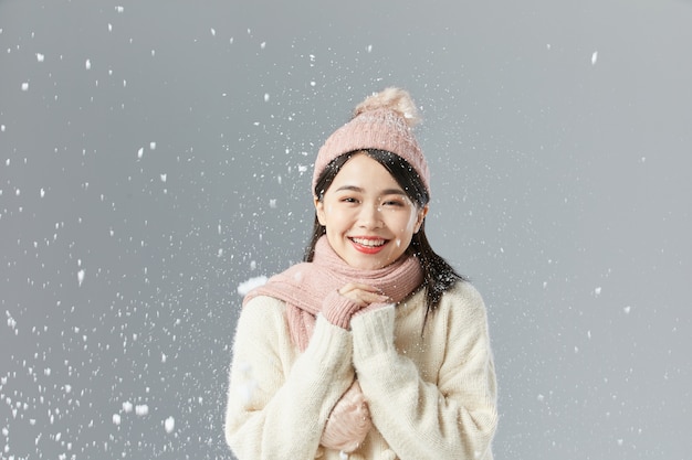 Belle femme asiatique dans un pull blanc et un chapeau