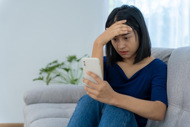 Belle femme asiatique déçue et triste après avoir reçu de mauvaises nouvelles par téléphone Fille stressée confondue avec des problèmes malheureux dans la vie se disputant avec son petit ami