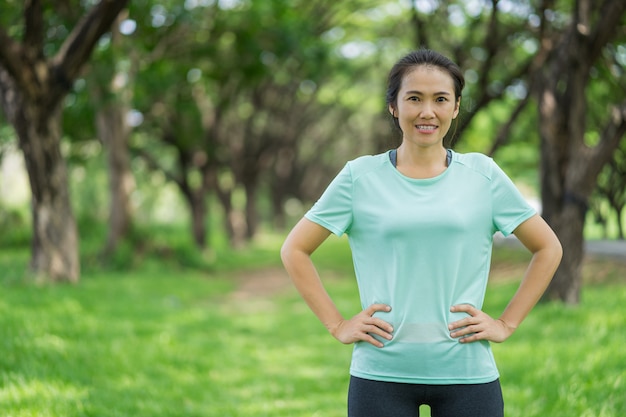 Belle femme asiatique exerce dans le parc.