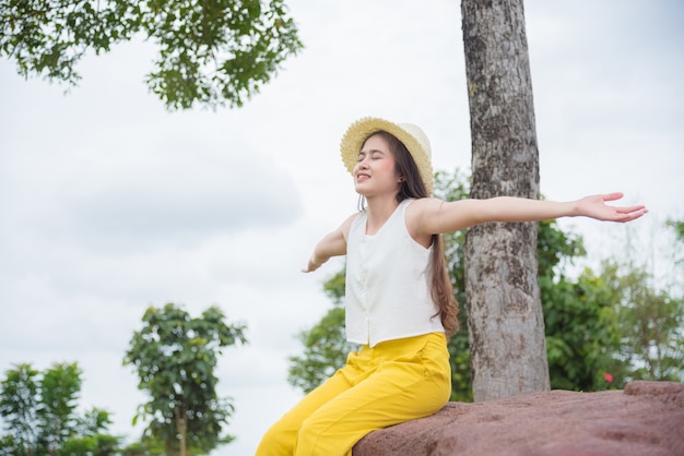 Belle femme asiatique faisant les mains tendues et sourire avec bon caractère en forêt