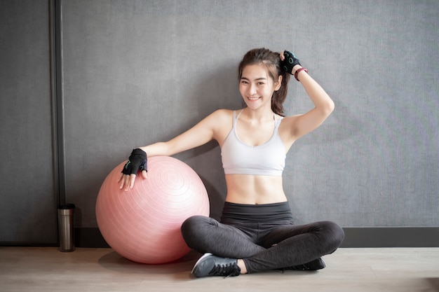 Belle femme asiatique fait de l'exercice dans la salle de gym