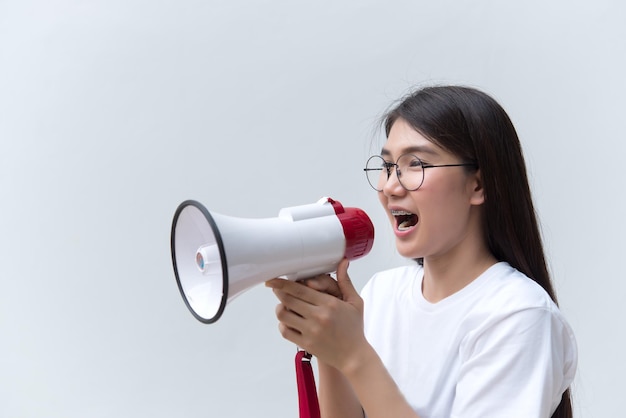 Belle femme asiatique avec haut-parleur à la main sur fond blancconcept de femme en colèreThaïlande