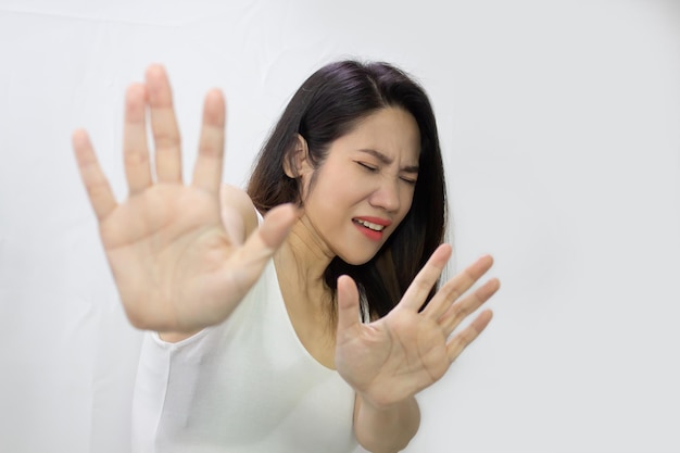 Une belle femme asiatique lève les deux mains pour refuser quelque chose avec peur et dépression