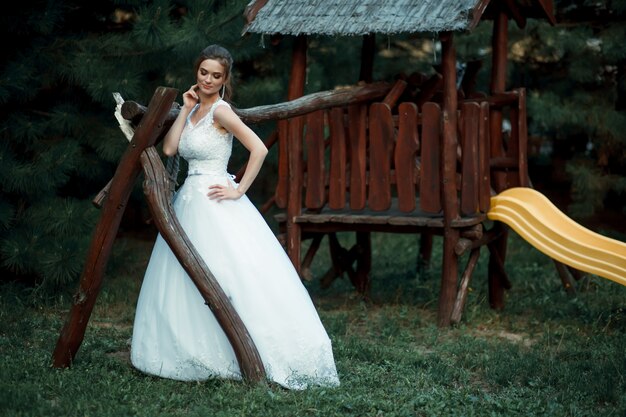 Belle femme asiatique mariée en robe de mariée blanche debout dans un jardin verdoyant