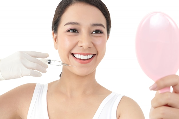 Belle femme asiatique a un médecin pour injecter le visage pour traiter l'acné. Concept de beauté de soins de la peau.