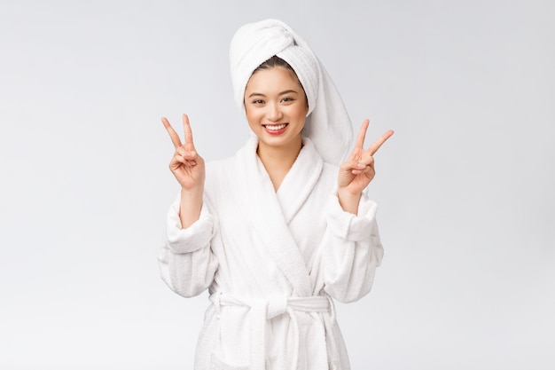 Belle femme asiatique montrant le signe de la paix ou deux doigts avec un sentiment heureux isolé sur