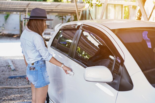 Belle femme asiatique ouvrir la porte de la voiture prête à conduire