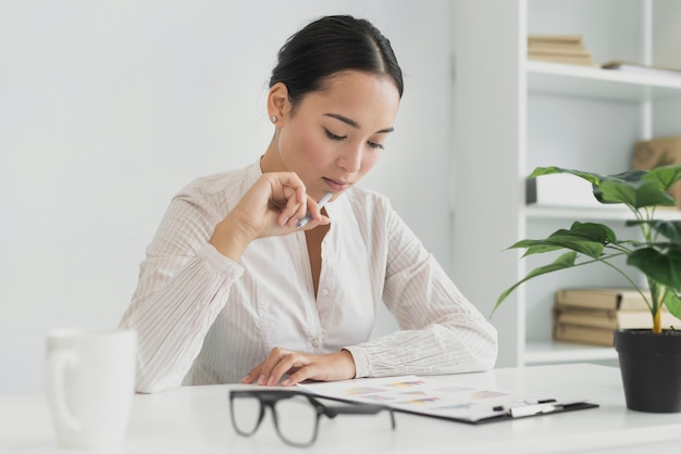 Photo belle femme asiatique pensant au bureau