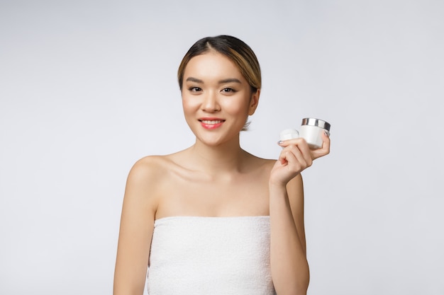 Belle femme asiatique présentant le produit isolé sur fond blanc.