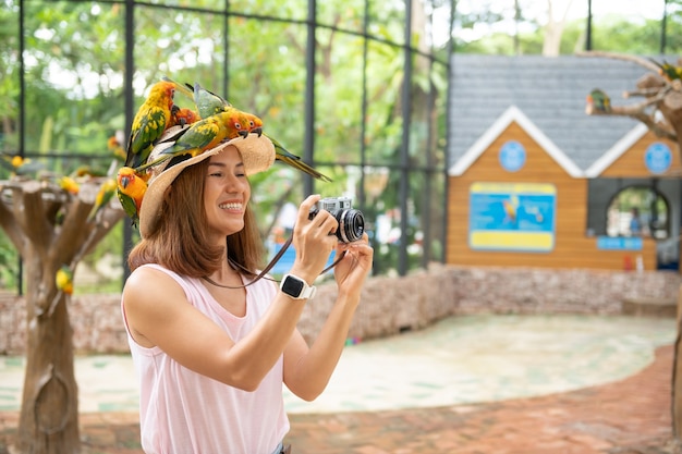 Belle femme asiatique profitant d'un oiseau d'amour à portée de main