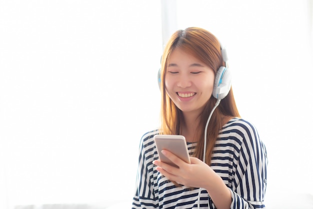 Belle femme asiatique profiter écouter de la musique avec un casque