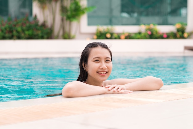 Belle femme asiatique souriante dans une piscine