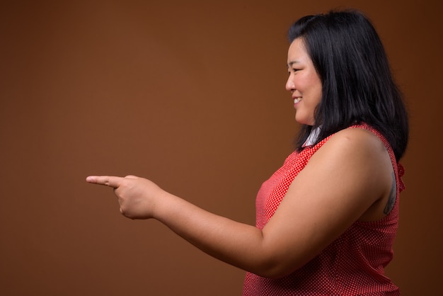 belle femme asiatique en surpoids vêtue d'une robe rouge