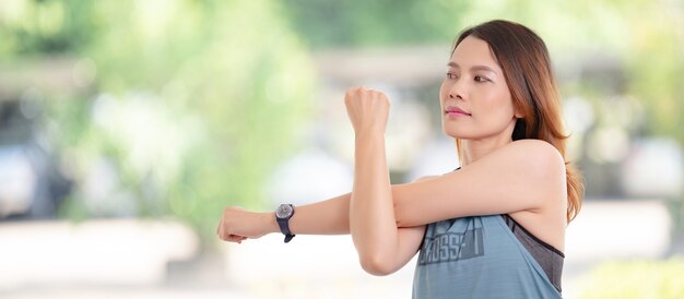 Une belle femme asiatique en tenue de sport faisant des étirements avant l'exercice d'entraînement à la maison