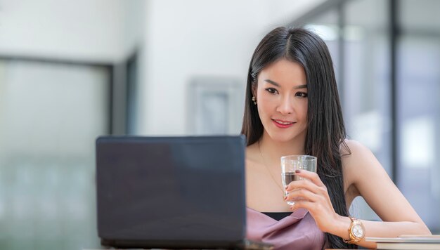 Belle femme asiatique travaillant au bureau