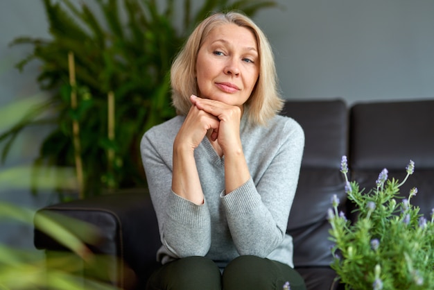 Belle femme assise sur un canapé à la maison