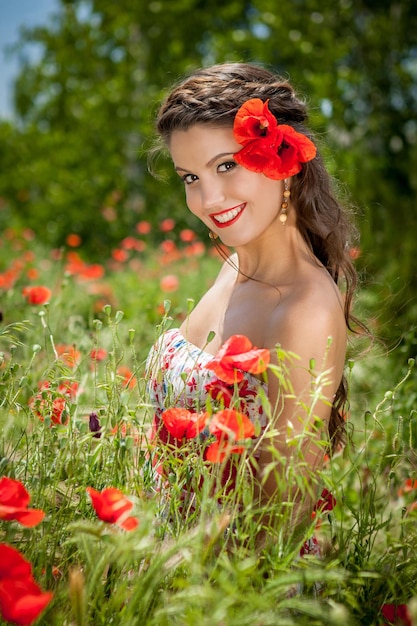 Belle femme assise dans la fleur de pavot