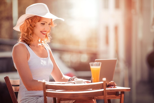 Belle femme assise et travaillant sur un ordinateur portable