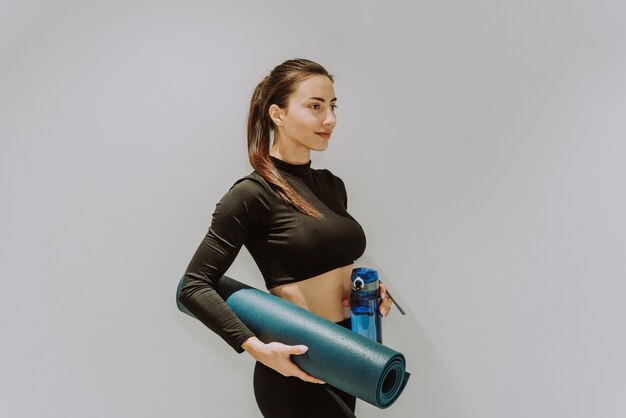 Belle femme athlétique s'entraînant dans une salle de sport, faisant des exercices d'étirement avant l'entraînement