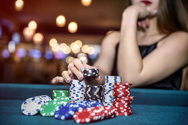 Belle femme au casino prenant des jetons de pile